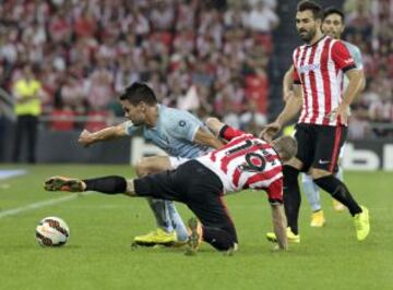 El delantero del Athletic Club de Bilbao Iker Muniain (c) pelea desde el suelo un balón con el centrocampista del Eibar Jon Errazti (i), durante el partido de la sexta jornada de Liga en Primera Division que se juega esta noche en San Mamés.