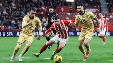 23-12-24. VÍCTOR CAMPUZANO, ENTRE DOS JUGADORES RIVALES, EN EL PARTIDO DEL SPORTING FRENTA AL MÁLAGA.