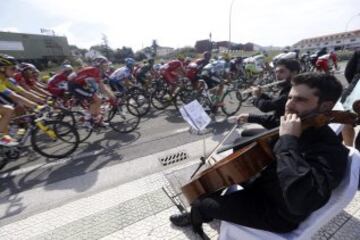 Unos músicos tocan al paso del pelotón de la Vuelta Ciclista a España.