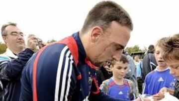 <b>DUDA. </b>La estrella de Francia, Ribéry, firma a unos niños un balón.