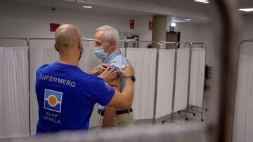 GRAFAND2888. SEVILLA, 18/10/2021.-Un enfermero inocula la tercera dosis de la vacuna contra la covid-19 a un hombre mayor de 70 a&ntilde;os perteneciente al Distrito Sanitario de Sevilla, que ha iniciado hoy lunes, en la Facultad de Derecho de la capital 