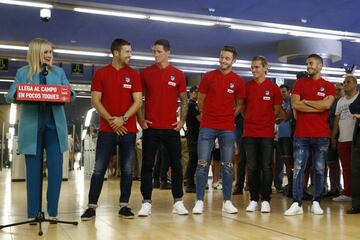 La presidenta de la Comunidad, Cristina Cifuentes, junto al presidente del Atlético de Madrid, Enrique Cerezo, y el entrenador del equipo, Diego Pablo Simeone y varios jugadores de la plantilla rojiblanca ,durante el acto de promoción del uso del metro para el acceso al estadio Wanda Metropolitano del Atletico de Madrid. 