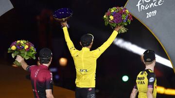 Paris (France), 28/07/2019.- Colombia&#039;s Egan Bernal (C) of Team Ineos is flanked by his second placed British teammate Geraint Thomas (L) and third placed Dutch rider Steven Kruijswijk (R) of Team Jumbo Visma on the podium wearing the overall leader&