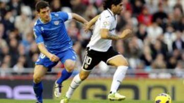 El centrocampista argentino del Valencia Ever Banega (d) controla el bal&oacute;n ante el delantero del Rayo Vallecano Francisco Medina &quot;Piti&quot;, durante la decimosexta jornada de liga en Primera Divisi&oacute;n que se disputa en el estadio de Mestalla. 