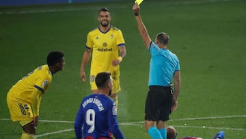 Mateu Lahoz, &aacute;rbitro espa&ntilde;ol, muestra una tarjeta amarilla a un jugador del C&aacute;diz CF durante un partido de LaLiga Santander ante la SD Eibar.