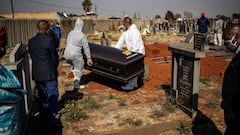 Relatives observe undertakers moving a casket containing the remains of a COVID-19 coronavirus patient during a funeral at the Avalon cemetery in Soweto, on July 24, 2020. (Photo by Michele Spatari / AFP)