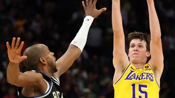 Austin Reaves #15 of the Los Angeles Lakers shoots over Khris Middleton #22 of the Milwaukee Bucks during the second overtime at Fiserv Forum on March 26, 2024 in Milwaukee, Wisconsin. The Lakers won the game 128-124 in double overtime.