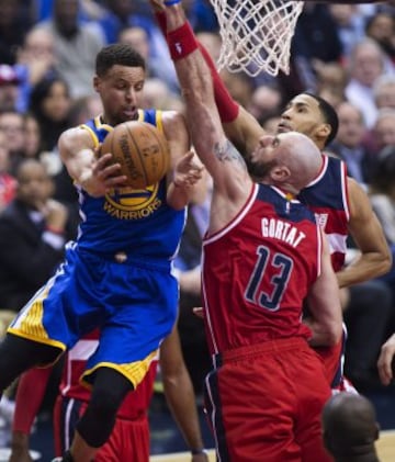 Stephen Curry disputa el balón con Marcin Gortat y Garrett Temple.