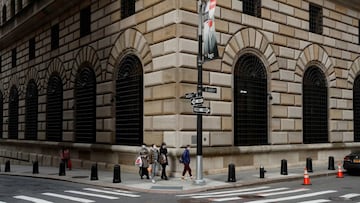 FILE PHOTO: People walk wearing masks outside The Federal Reserve Bank of New York in New York City, U.S., March 18, 2020. REUTERS/Lucas Jackson//File Photo