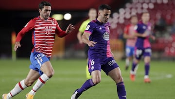 GRANADA, SPAIN - NOVEMBER 22: Bruno Gonzalez of Real Valladolid passes the ball whilst under pressure from German Sanchez of Granada CF during the La Liga Santander match between Granada CF and Real Valladolid CF at Estadio Nuevo Los Carmenes on November