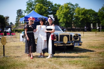Varias aficionadas a las carreras posan frente a un Lincoln Continental en Ascot.