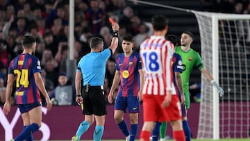 El árbitro István Kovács muestrsa la cartulina roja al '5' del Barcelona tras revisar la jugada en el VAR.