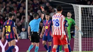 El árbitro István Kovács muestrsa la cartulina roja al '5' del Barcelona tras revisar la jugada en el VAR.