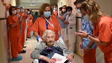 Health workers salute Elena, 104, as she leaves the Gregorio Maranon hospital, after being treated for the coronavirus disease (COVID-19) and discharged, in Madrid, Spain December 14, 2020. Hospital Gregorio Maranon/Handout via REUTERS ATTENTION EDITORS -