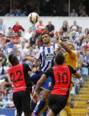 El portero de la UD Almería Rubén Martínez (d) despeja el balón ante el delantero portugués del Deportivo de la Coruña Helder Postiga (c), durante el partido de la sexta jornada de Liga de Primera División, disputado esta tarde en el estadio de Riazor.