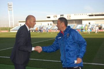 Zinedine Zidane y Fran Alcoy se saludan antes del Castilla-Talavera de la temporada 2015-2016, último partido del francés en el Di Stéfano como entrenador del filial del Real Madrid.