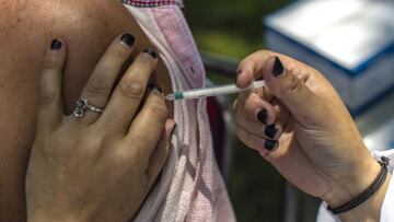 SRINAGAR, KASHMIR, INDIA - MAY 26: A Kashmiri Muslim nurse, injects a dose of the Indian-made version of the Oxford/AstraZeneca vaccine, Covishield COVID-19 Vaccine to a Kashmiri man in a park on May 26, 2021 in Srinagar, the summer capital of Indian admi
