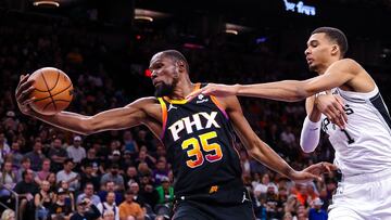Kevin Durant, alero de Phoenix Suns, lucha por el balón con Victor Wembanyama, pívot de San Antonio Spurs.