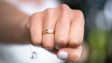 A closeup of the fist of a woman with a wedding ring on her ring finger