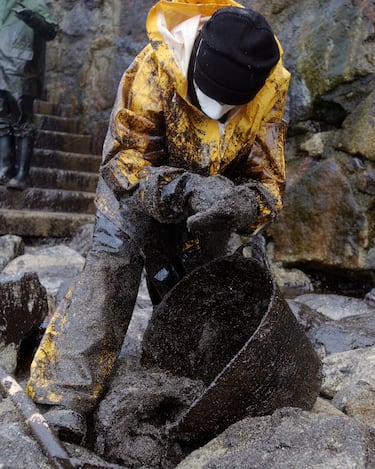 Un voluntario durante la recogida del fuel vertido. 