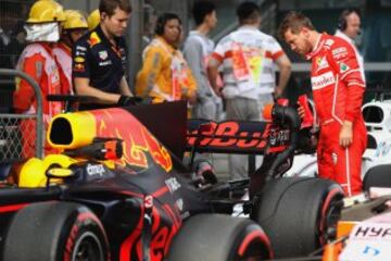 Sebastian Vettel looks at Daniel Ricciardo's car.