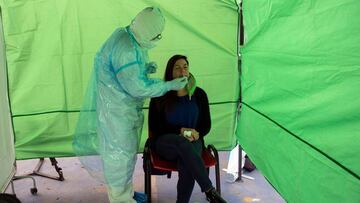 A woman undergoes a PCR test for the novel coronavirus at a control post in the municipality of Renca, Santiago on August 26, 2020. - After critical weeks in May and June, Chile managed to keep the new cases of coronavirus stable in most of the country. T