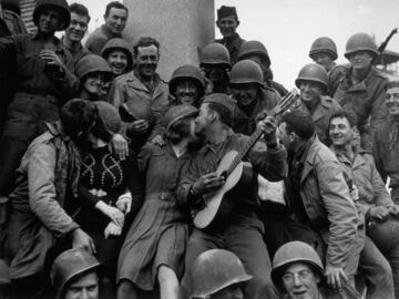 Una multitud feliz de soldados estadounidenses recibe una 'curiosa' bienvenida por parte de las habitantes de Cherburgo, tras su liberación.