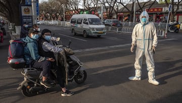 BEIJING, CHINA - APRIL 12: A health worker waits in the street wearing protective clothing to prevent the spread of COVID-19 as he waits to do a routine patient transfer during evening rush hour on April 12, 2022 in Beijing, China. China has stepped up efforts to control a recent surge in coronavirus cases across the country, imposing a lockdown on the countries largest city of Shanghai and the entire province of Jilin. Local authorities across the country have carried out mass testing, including in the capital Beijing, as China tries to maintain its zero COVID policy. (Photo by Kevin Frayer/Getty Images)