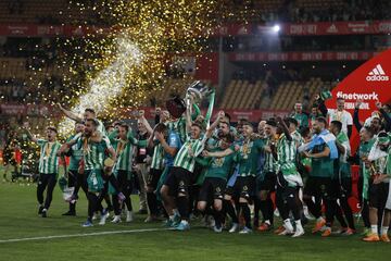 Los jugadores del Betis campeones de Copa celebran en el césped su triunfo.