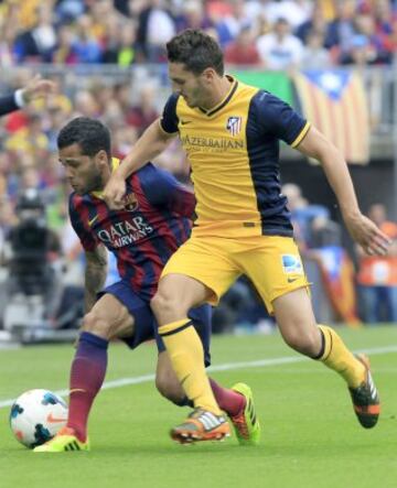 El defensa brasileño del FC Barcelona Daniel Alves (i) y el centrocampista del Atlético de Madrid Koke luchan por el balón.