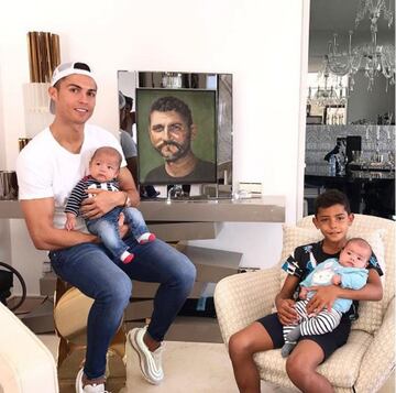 El 2017 será para siempre muy especial para Cristiano. En la foto, posa con su hijo mayor, los mellizos, Eva y Mateo, y una imagen de su padre. 