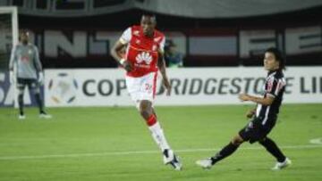 Sherman Cárdenas (der) persigue al defensor Yerry Mina en el partido entre Santa Fe y Atlético Mineiro en Bogotá.