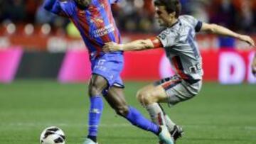 El delantero nigeriano del Levante, Martins Obafemi (i), sujetado por el centrocampista de Osasuna, Oier Sanjurjo, durante el encuentro correspondiente a la vigésima quinta jornada de liga en Primera División que han disputado esta noche en el estadio Ciutat de Valencia.