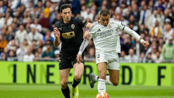 El delantero franc¨¦s del Real Madrid Kylian Mbapp¨¦ (d) pelea un bal¨®n con el defensa del Valencia C¨¦sar T¨¢rrega durante el partido de LaLiga entre el Real Madrid y el Valencia disputado este s¨¢bado en el estadio Santiago Bernab¨¦u en Madrid. EFE/Chema Moya