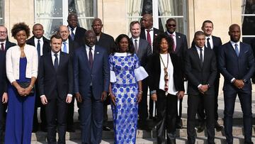 French President Emmanuel Macron (2nd L), Liberian President George Weah (3rd L) and his wife Clar (C) pose for a family picture with Paris Saint-Germain's player Kylian Mbappe (2nd R) and guests before a lunch at the Elysee Palace in Paris, on Febru