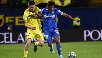 Villarreal's Spanish midfielder Moi Gomez (L) vies with Getafe's Uruguayan defender DamixE1n Nicolas Suarez during the Spanish league football match between Villarreal CF and Getafe CF at la Ceramica Stadium in Villarreal on December 21, 2019.