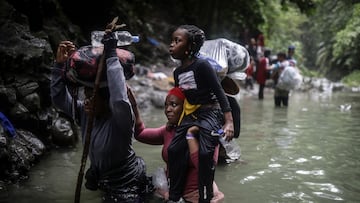 Haitian migrants wade through water as they cross the Darien Gap from Colombia to Panama in hopes of reaching the U.S., Tuesday, May 9, 2023. Pandemic-related U.S. asylum restrictions, known as Title 42, are to expire Thursday, May 11. (AP Photo/Ivan Valencia)