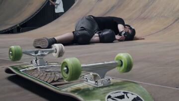 Tony Hawk estirado en el suelo de su Vert en California (Estados Unidos), tras caer con la tabla de skate, verde, en primer plano. 