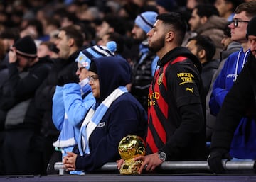 Un aficionado del Manchester City en la grada del Etihad Stadium con una rplica del Baln de Oro.