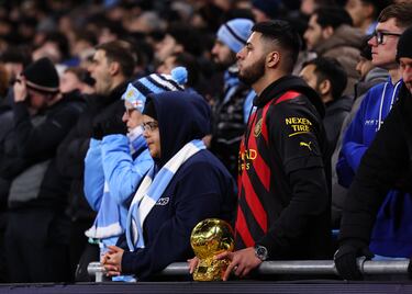 Un aficionado del Manchester City en la grada del Etihad Stadium con una réplica del Balón de Oro.