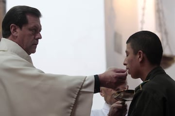 Sacerdote entrega una hostia a un feligrés en eucaristía católica