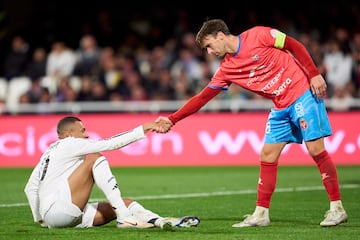 Cristhian Britos tiende su mano para ayudar a levantarse al jugador francs del Real Madrid.