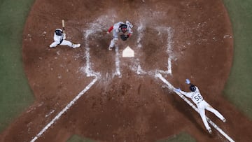 07 October 2021, US, St. Petersburg: Rays' Randy Arozarena (R), slides into home plate as Red Sox catcher Christian Vazquez (C), anticipates the throw while Rays second baseman Brandon Lowe (L), and umpire Dan Bellino watch the play during the sevent