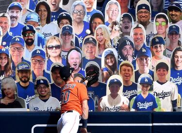 Kyle Tucker, de los Houston Astros, intenta alcanzar una bola durante un partido que finalmente se pierde en una grada poblada de un público muy singular: imágenes de seguidores de la Liga de béisbol estadounidense. Un panorama al que estos tiempos del coronavirus ya nos tiene acostumbrados.