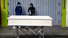 People stand next to a coffin holding the body of a family member who died after police raided a nightclub for hosting a party in violation of the coronavirus disease (COVID-19) restrictions, in Lima, Peru August 24, 2020. REUTERS/Sebastian Castaneda NO RESALES. NO ARCHIVES