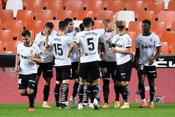 Valencia's players celebrate after scoring a goal during the Spanish League football match between Valencia and Real Madrid at the Mestalla stadium in Valencia on November 8, 2020. (Photo by JOSE JORDAN / AFP)