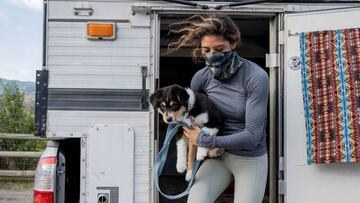 Una chica sale de su furgoneta de aventura con un tubular Buff que protege contra el coronavirus.