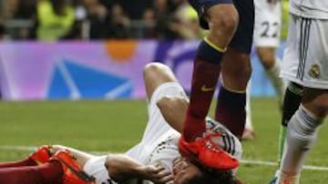 Barcelona&#039;s Sergio Busquets steps on the face of Pepe after Lionel Messi&#039;s scored a goal against Real Madrid during La Liga&#039;s second &#039;classic&#039; soccer match of the season at Santiago Bernabeu stadium in Madrid March 23, 2014.                REUTERS/Paul Hanna (SPAIN - Tags: SPORT SOCCER TPX IMAGES OF THE DAY)