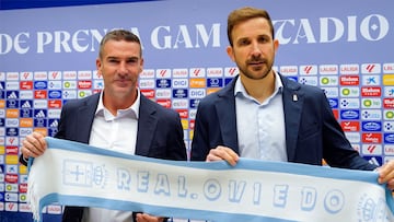 OVIEDO, 10/10/2025.- El nuevo entrenador del Oviedo, Luis Carrión (i), posa con una bufanda del club acompañado por el director general, Agustín Lleida, durante su presentación oficial, este viernes en el estadio Carlos Tartiere de la capital asturiana. El Real Oviedo afronta una nueva etapa con la llegada de Carrión como técnico tras la destitución de Veljko Paunovic ante los malos resultados en el regreso del club azul a la máxima categoría del fútbol español. EFE/Paco Paredes