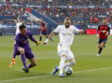 El jugador del Real Madrid, Benzema, controla el balón ante la salida del portero del Osasuna, Herrera. 